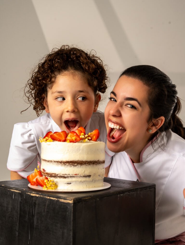 pastelera con niña a punto de probar una torta